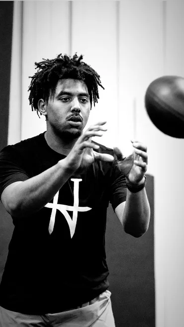 Young athlete tracking a football with hands ready to catch